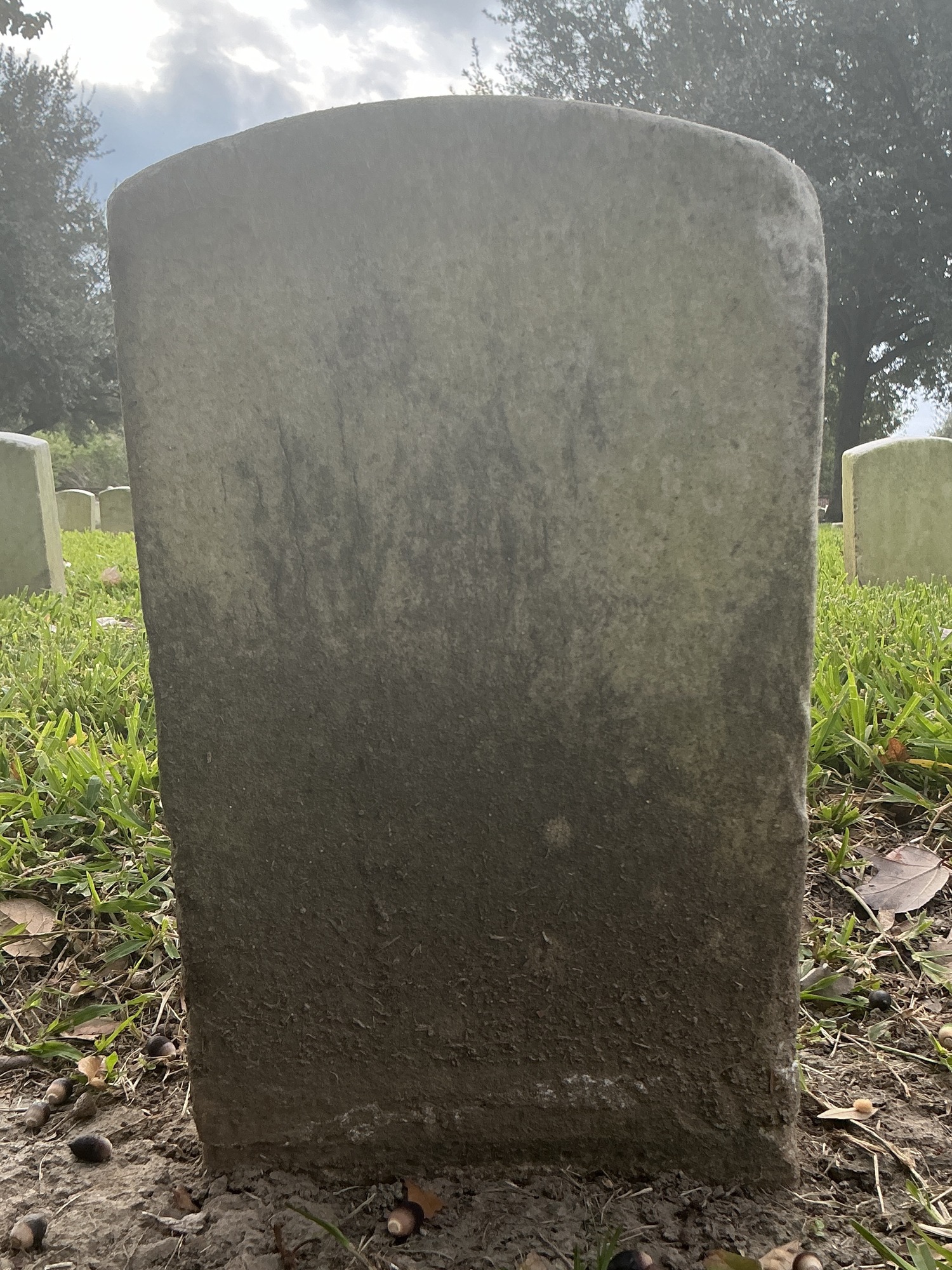 Back of historic upright marble headstone with recessed shield face.