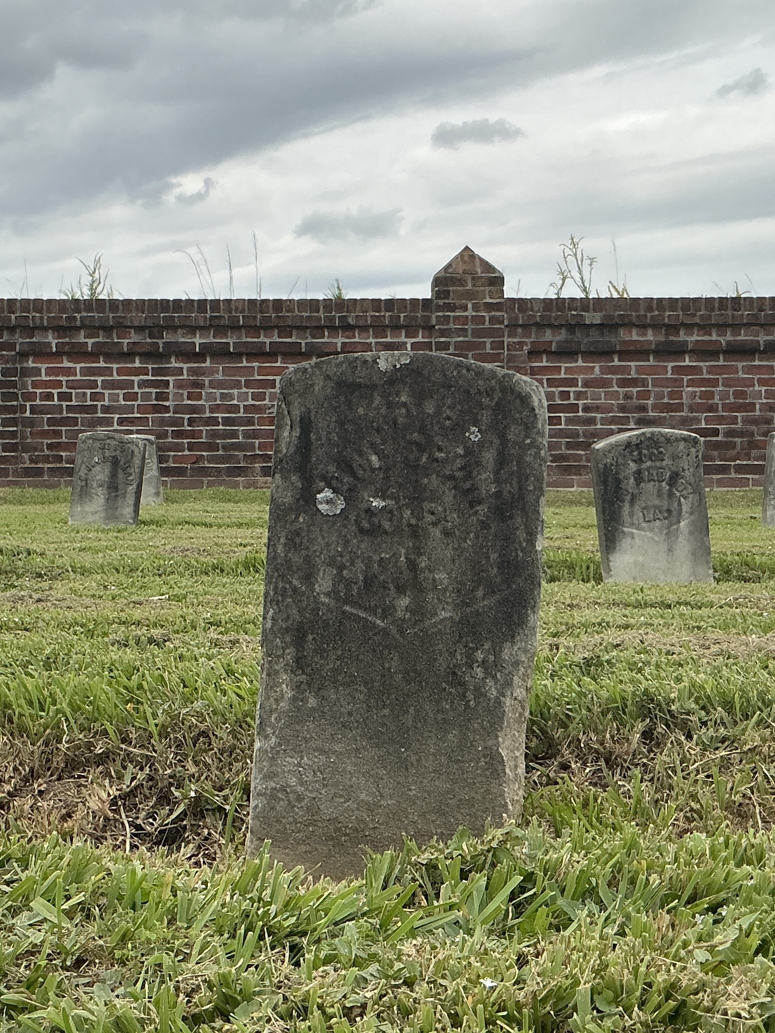 Front of historic upright marble headstone with recessed shield face.