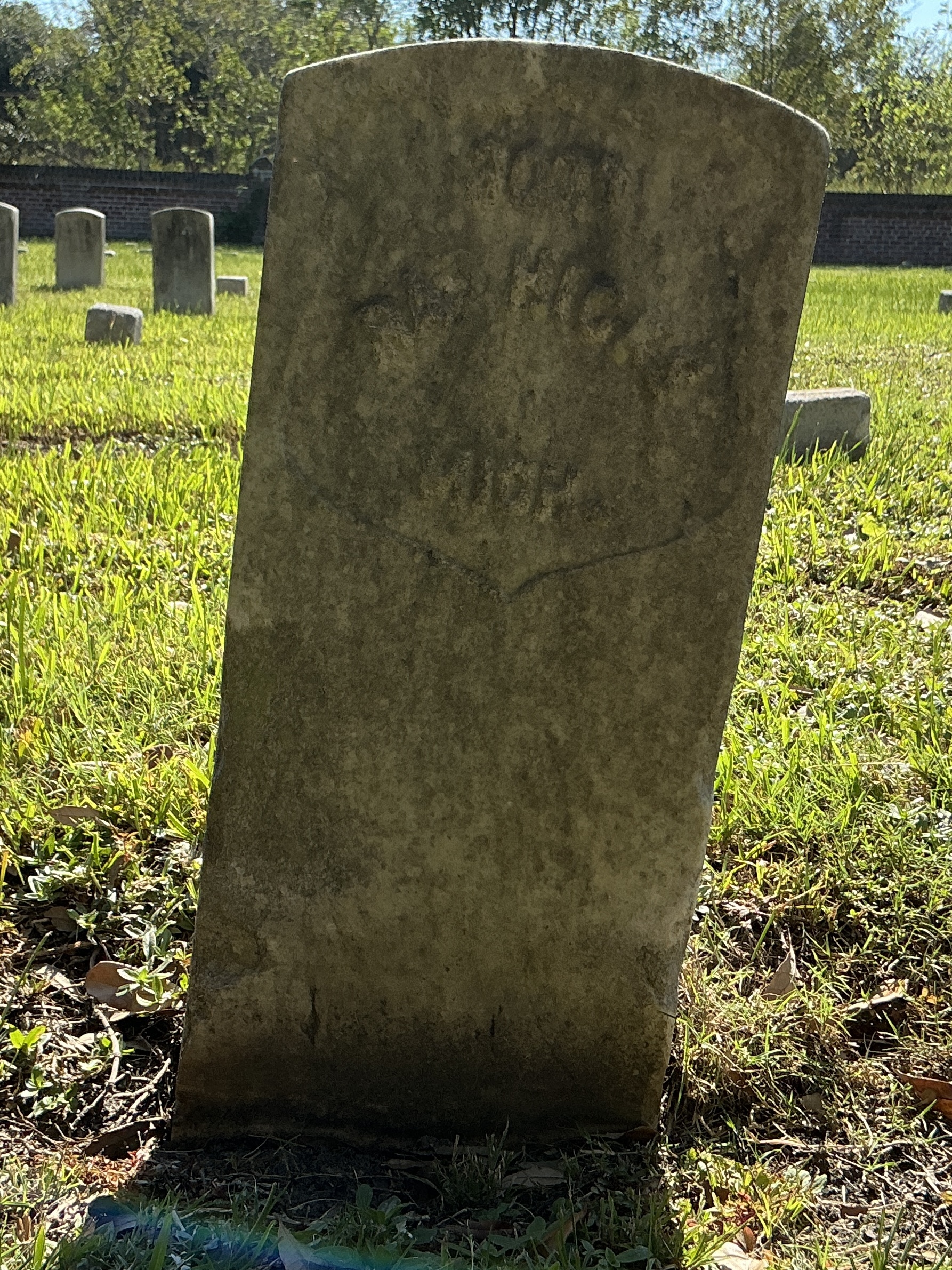 Front of historic upright marble headstone with recessed shield face.