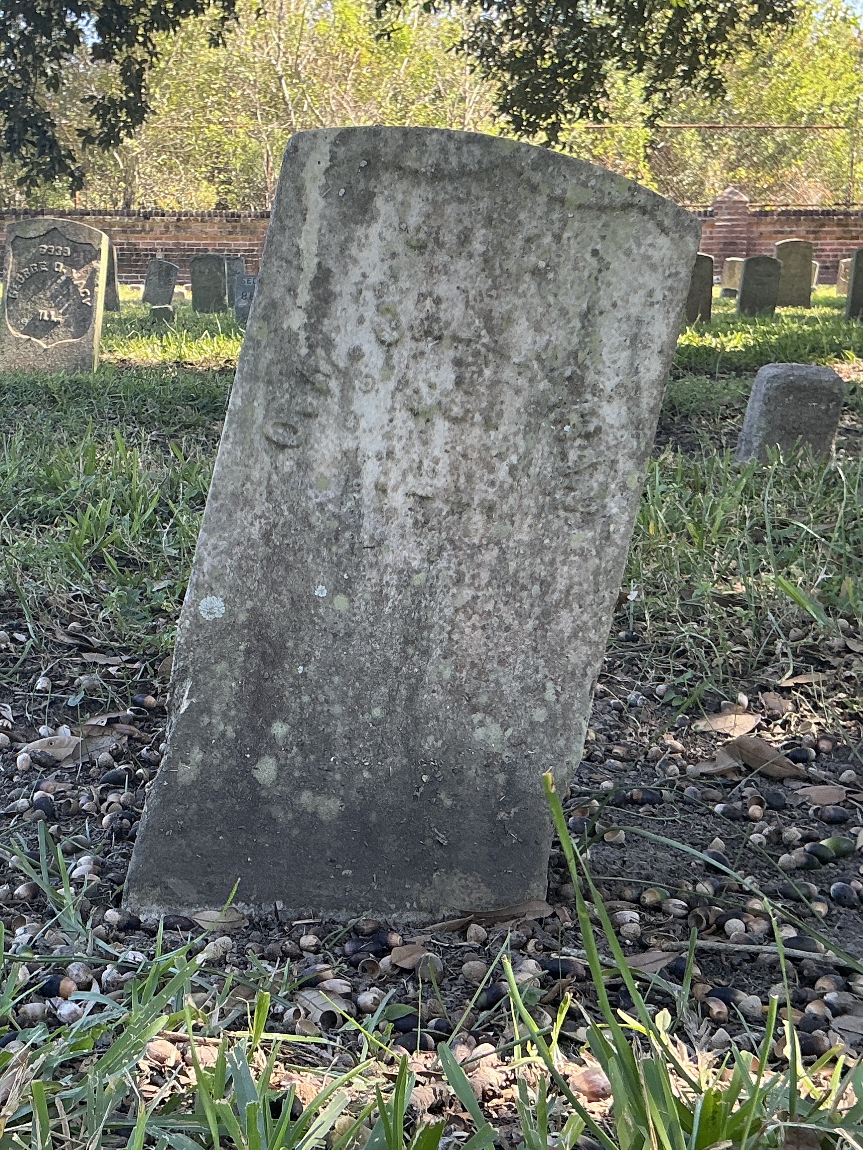 Front of historic upright marble headstone with recessed shield face.