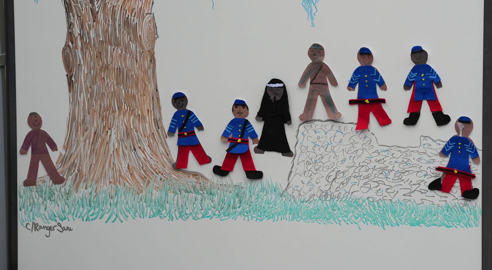 A group of felt soldiers and a nurse made by children.
