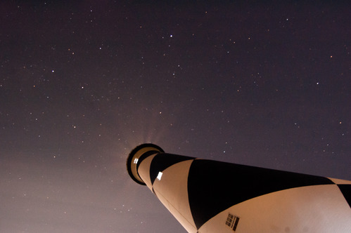 The starry night sky above the Cape Lookout Lighthouse