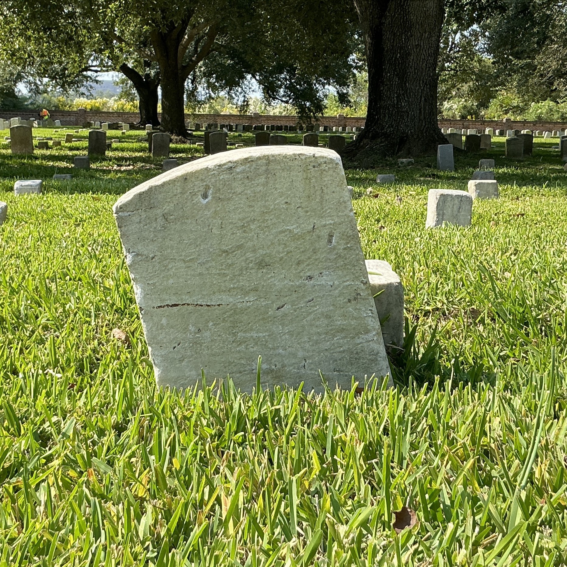 Back of historic upright marble headstone with recessed shield face.