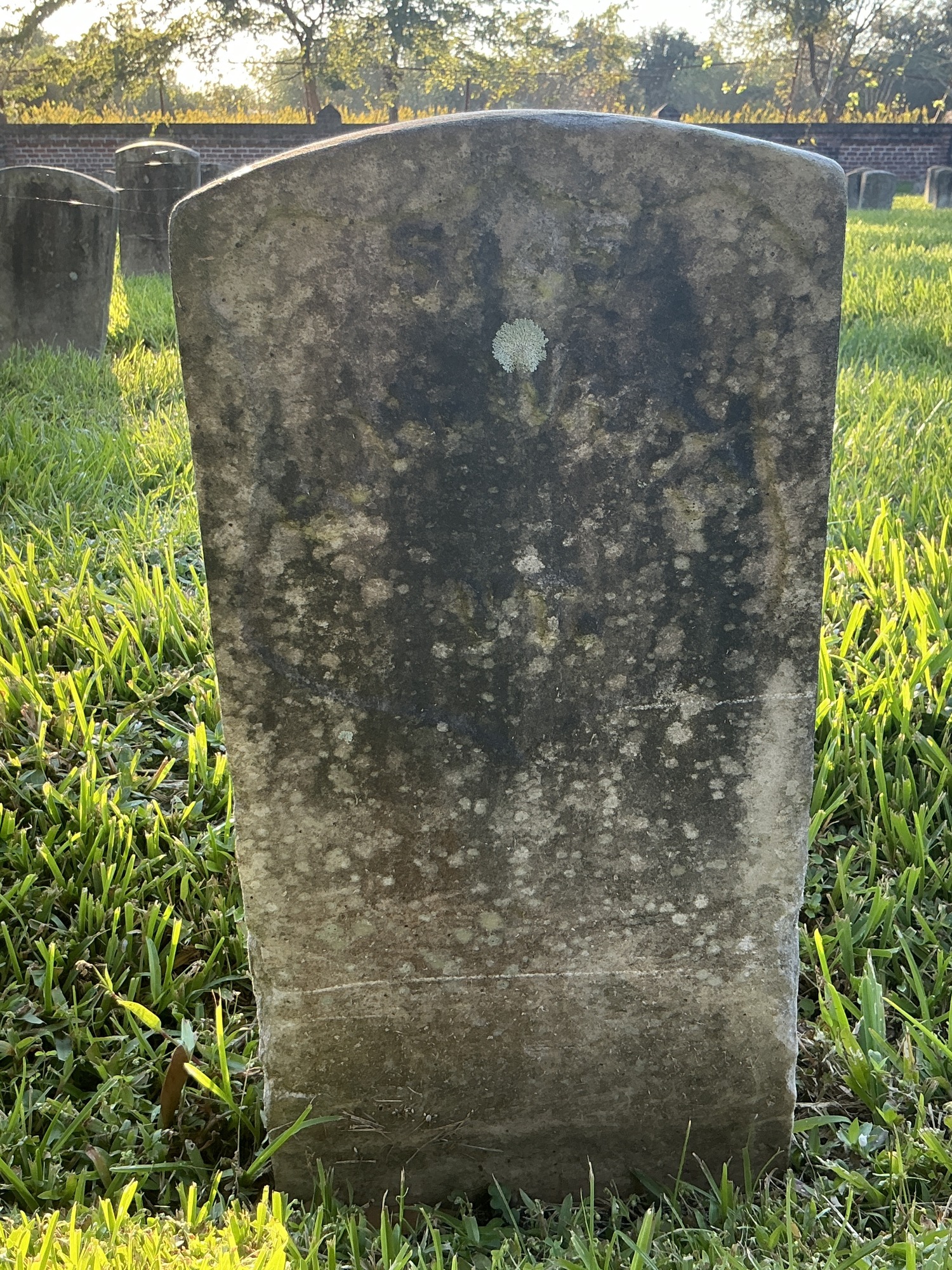 Front of historic upright marble headstone with recessed shield face.