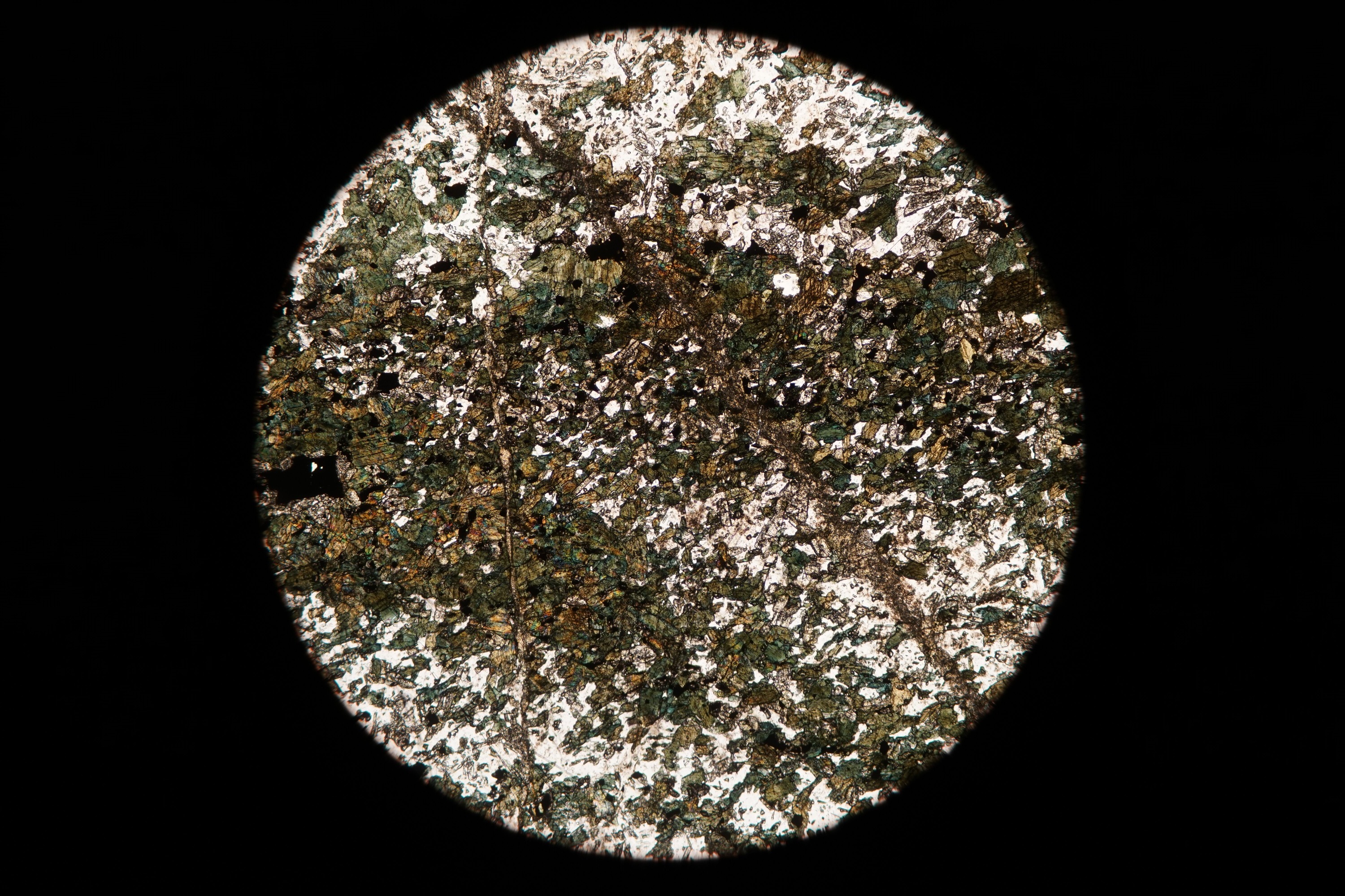 Circular microscopic image of rock structure.