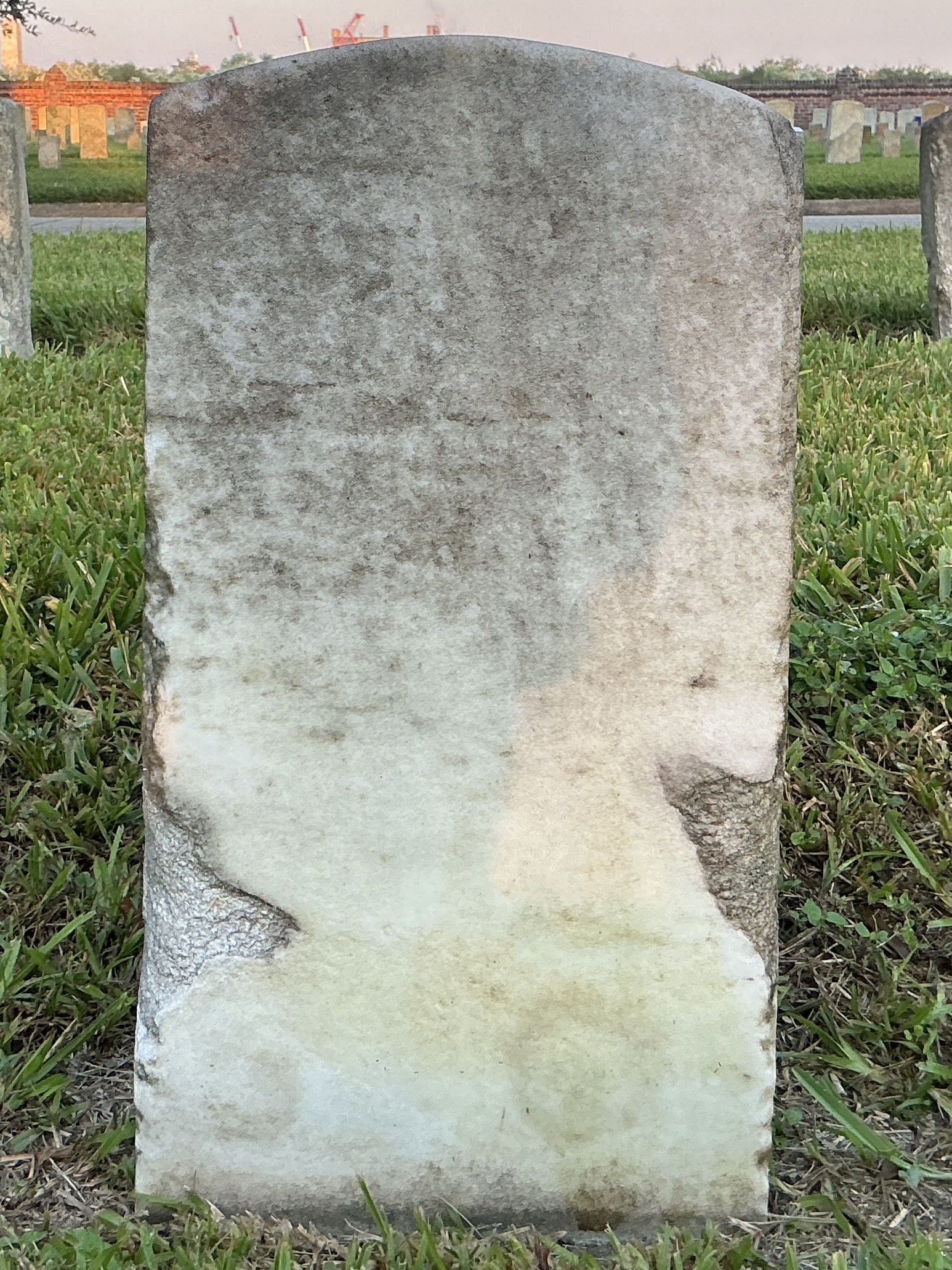 Back of historic upright marble headstone with recessed shield face.