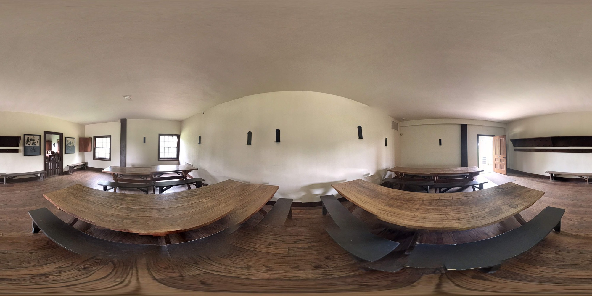 four large wooden tables with benches inside large room