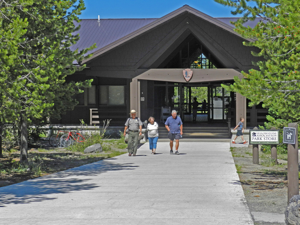 Brown building with pitched front roof and wide entrance doors.