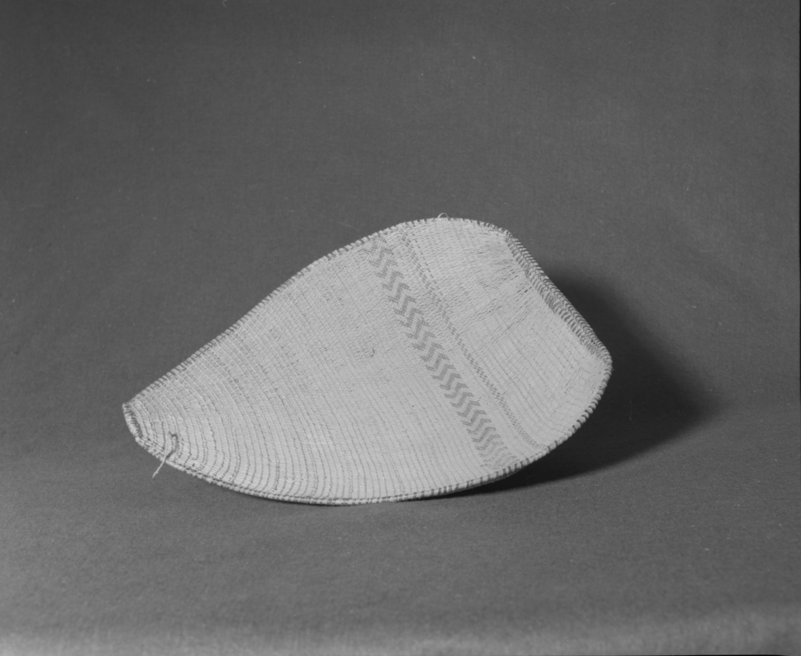 Marie Rozier Collection, Catalog No. 105. Object: Western Mono winnower. Dimensions: 15 x 19 x 3 1/2". Materials: Sourberry sticks; sedge root; split redbud; Ceanothus sp. rimstick. Technology: Diagonally twined; up to right slant of turns; type usually found among Western Mono. Collection History: Purchased from Mrs. Louise Fuentes, formerly owned by her sister, Carmelita Ralph. Photographed by Michael Dixon in December 1982. Catalogued by Craig Bates and Barbara Beroza. Yosemite Collections, National Park Service.