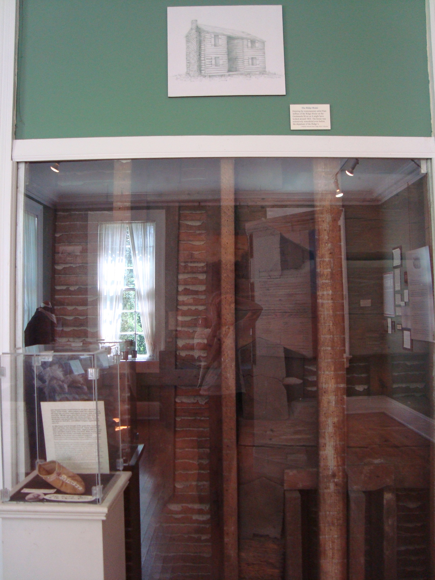 An exhibit enclosed by glass at the Chieftains Museum, Major Ridge Home in Rome, Georgia