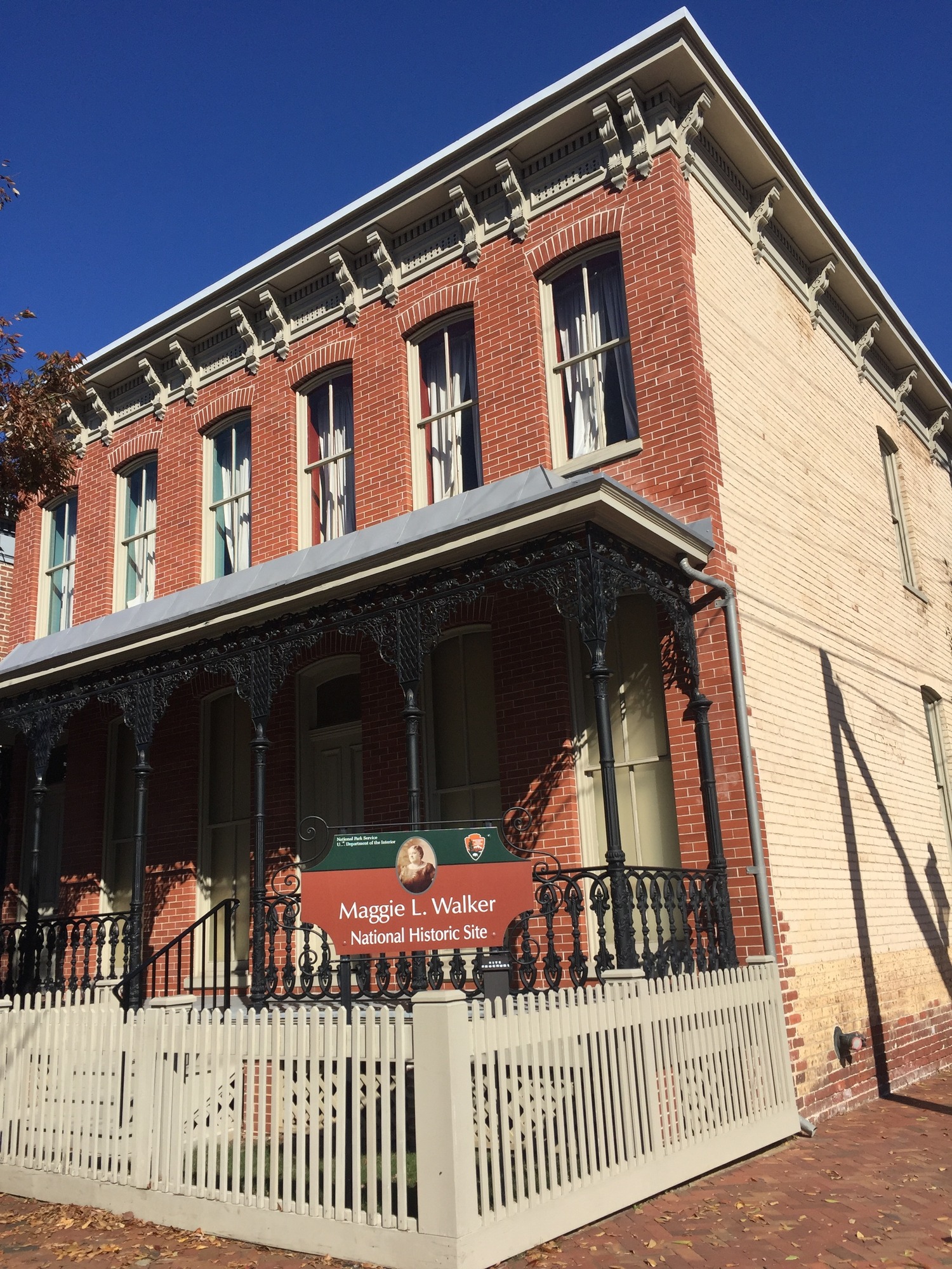 Two-story brick house with a porch and fence 