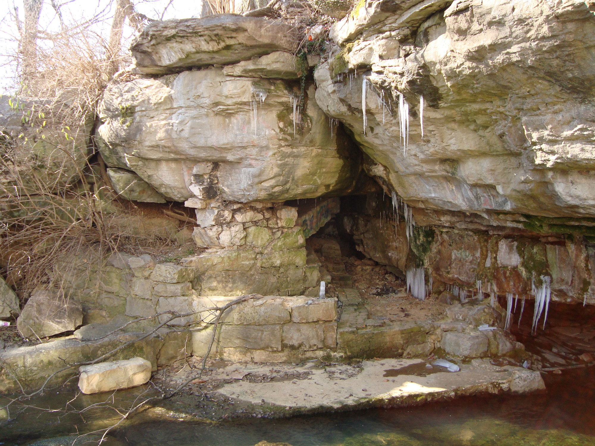 A rock formation with icicles hanging from it.
