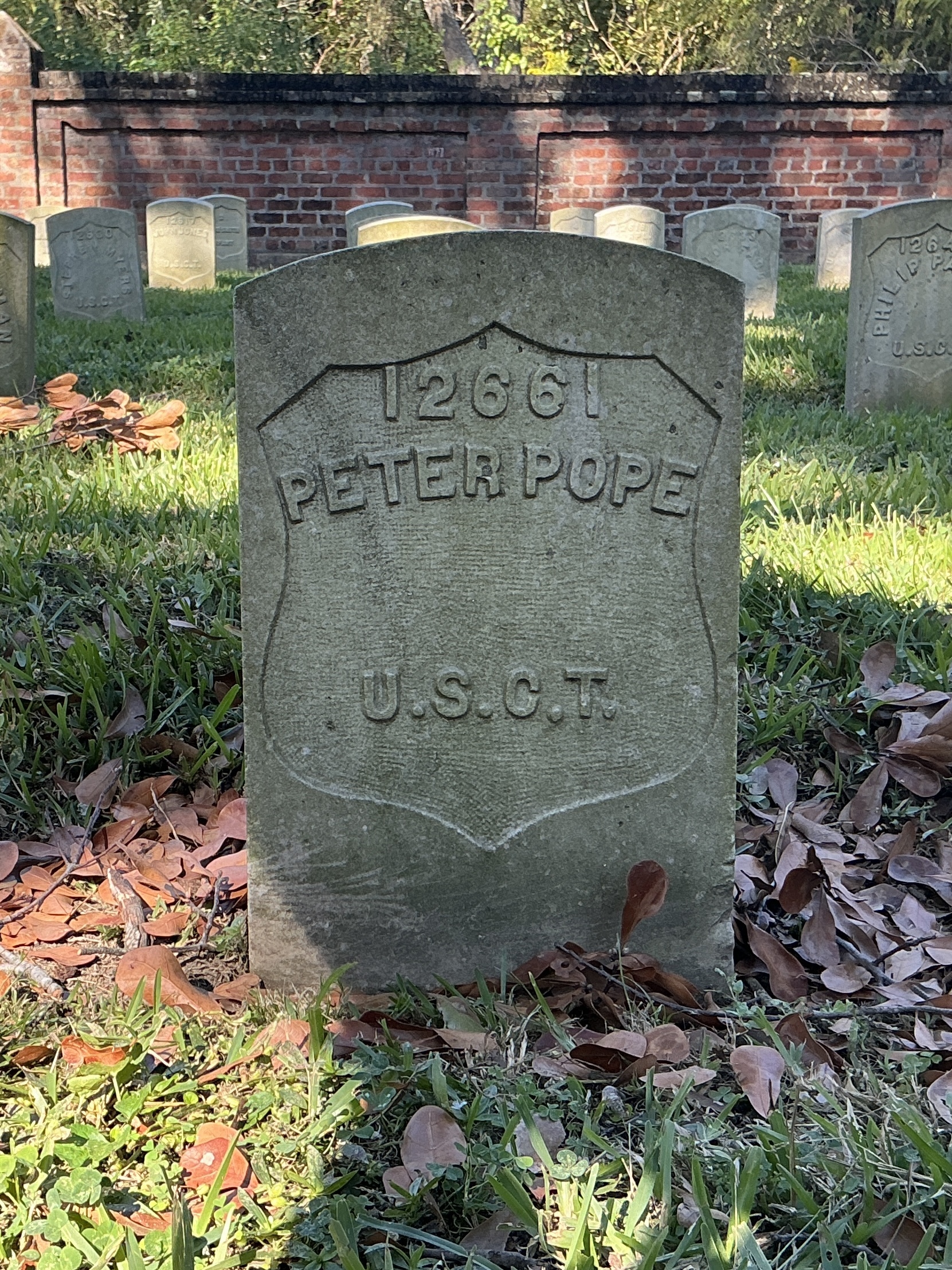 Front of historic upright marble headstone with recessed shield face.