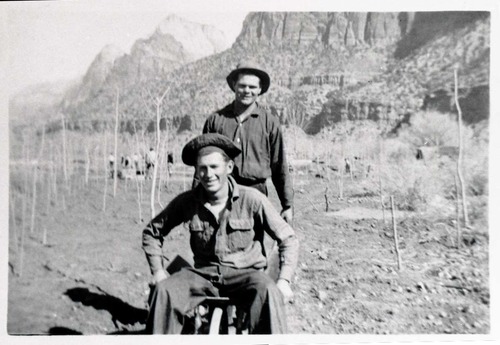 Two Civilian Conservation Corps (CCC) men riding in wheel barrow near the South Entrance.