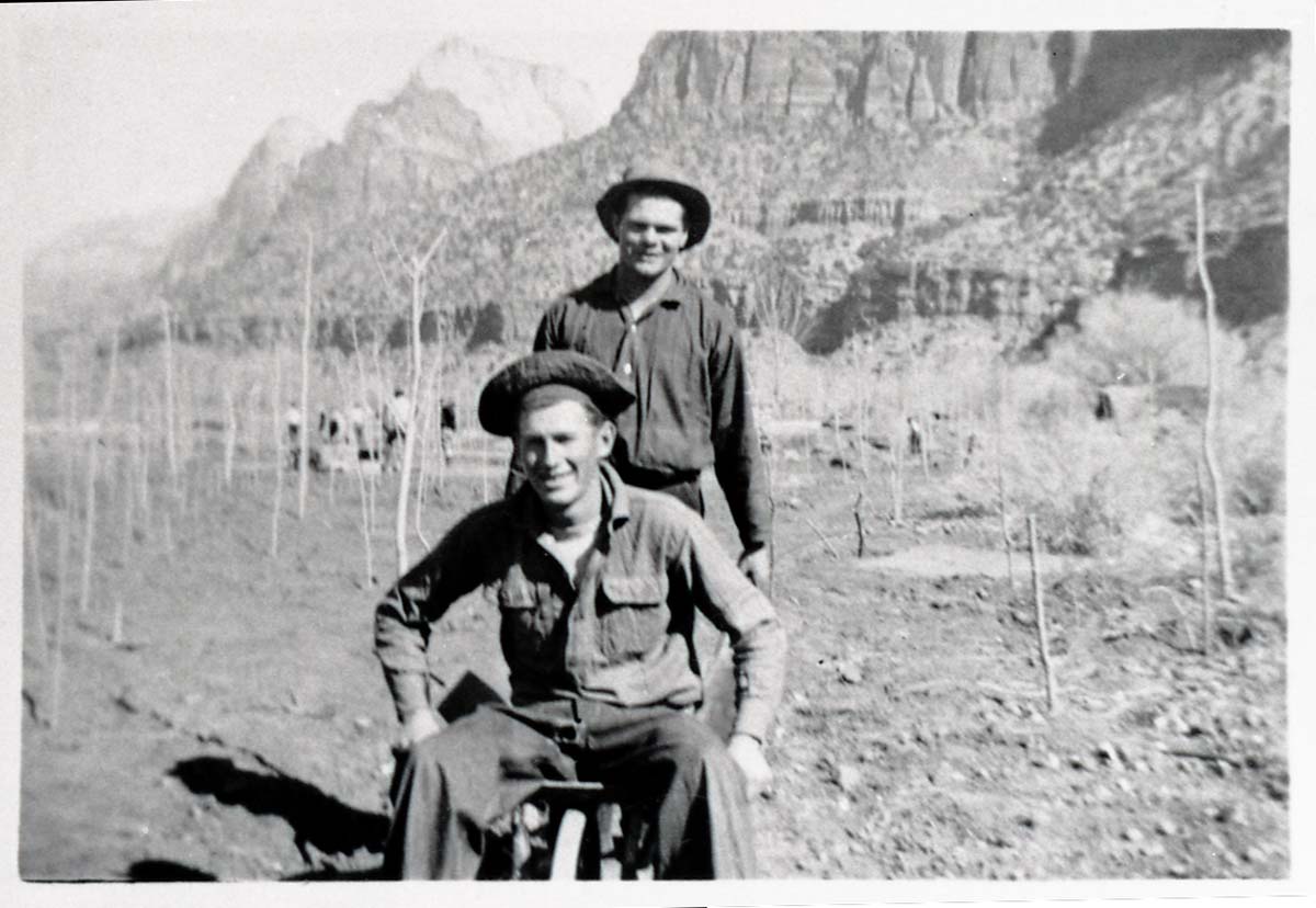 Two Civilian Conservation Corps (CCC) men riding in wheel barrow near the South Entrance.