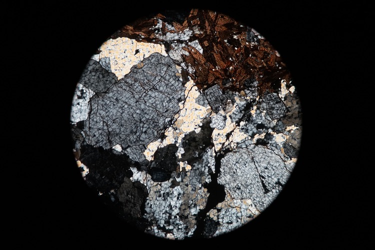 Circular microscopic image of rock structure.