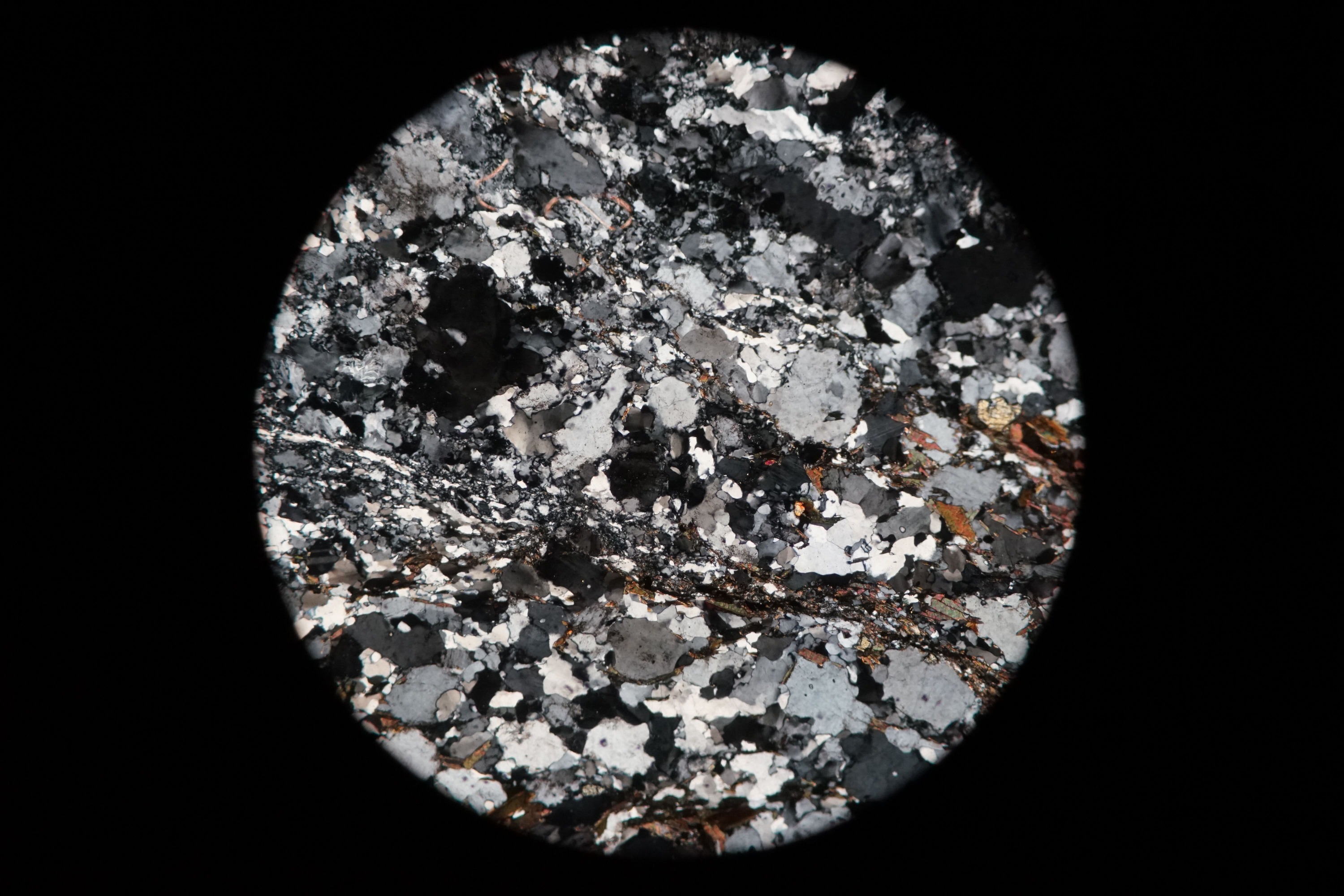 Circular microscopic image of rock structure.