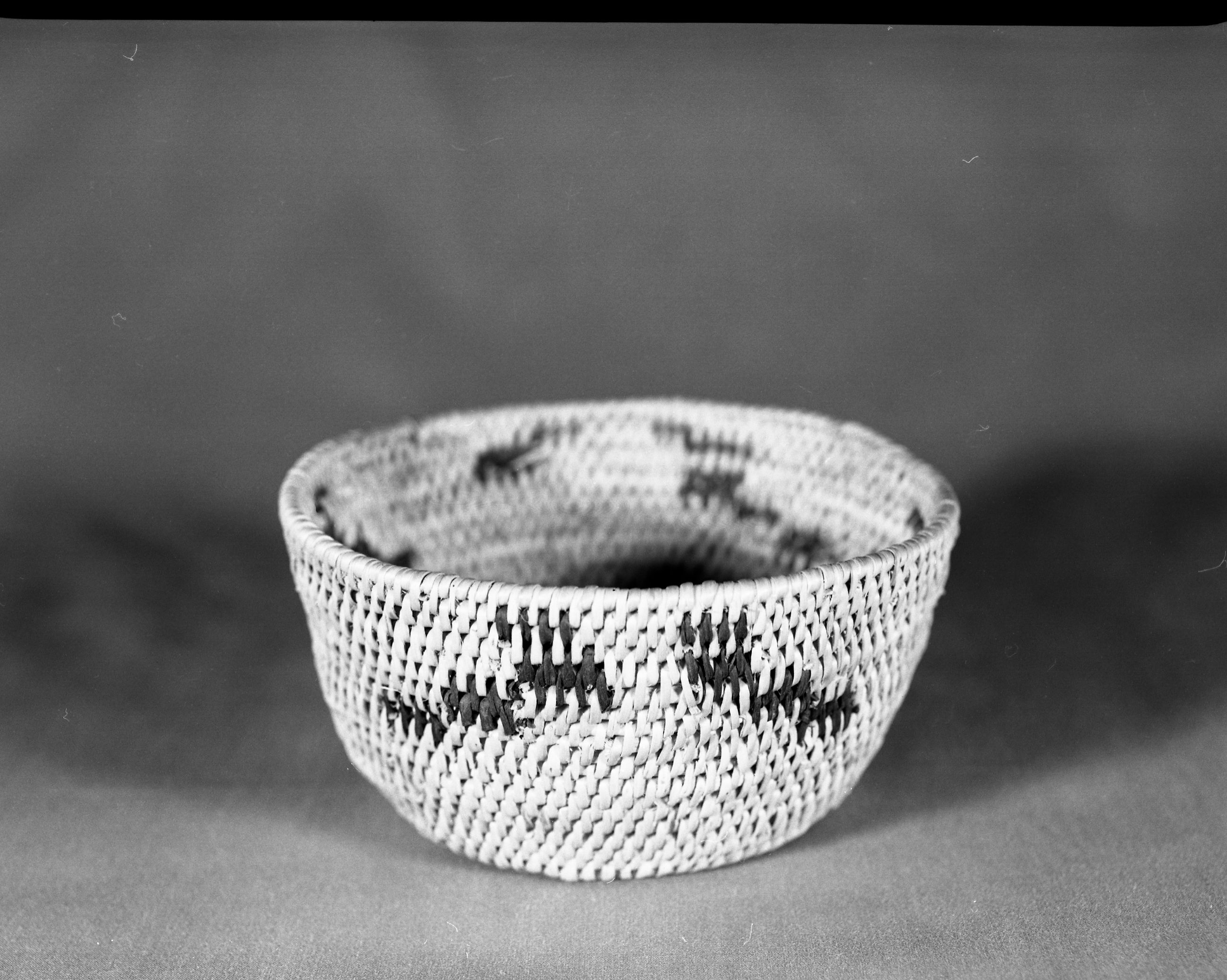 Private Collection. Object: Miwok basket. Dimensions: 6 x 3". Materials: Split bull pine and bracken fern root. Technology: Single rod, interlocking stitchm, fag ends trimmed on work face, moving ends trimmed on interior, rim stitched around once. Clockspring start overstitched.. Collection History: Probably made by Matilda, a Sonora Miwok. Photographed by Michael Dixon. Catalogued by Craig Bates and Barbara Beroza. Yosemite Collections, National Park Service.
