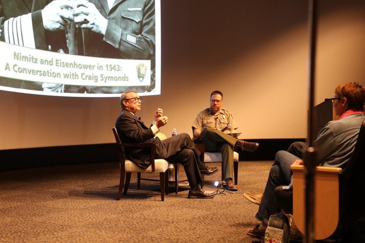 Two men seated in the front of a theater