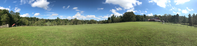 Panoramic view of a field and farm buildings