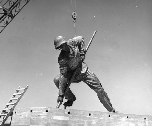 Bronze statue of Harlon Block being lowered onto the memorial's base with a crane