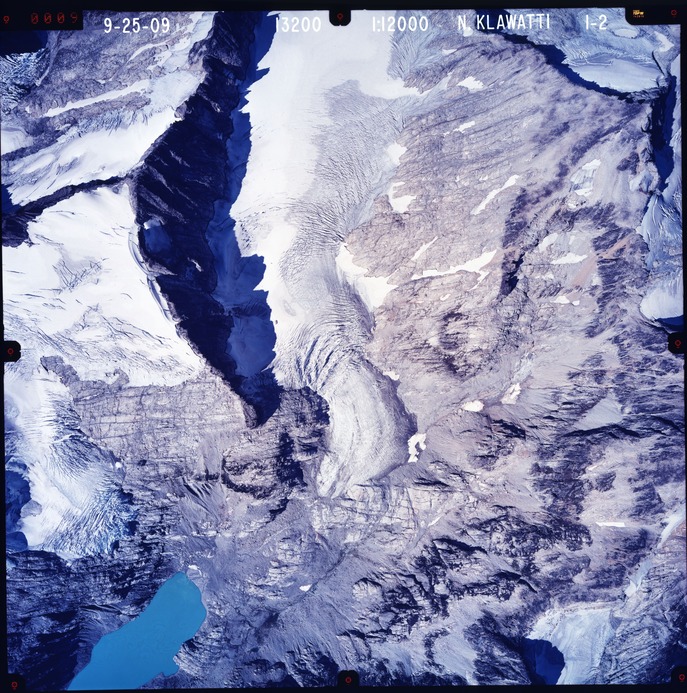 Color aerial photograph of glacier and snowfields on mountain peak.