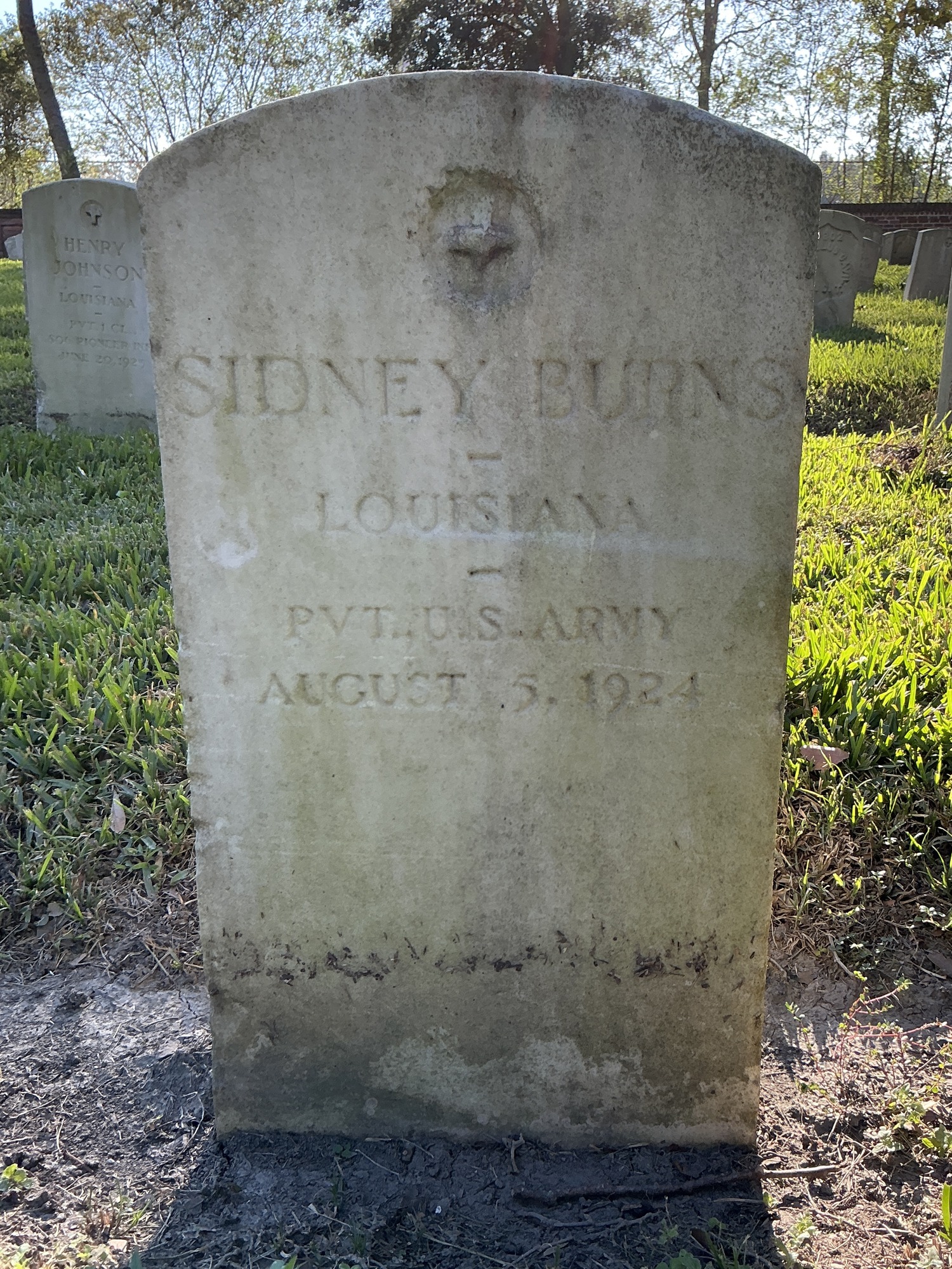 Front of upright marble headstone with recessed shield face.