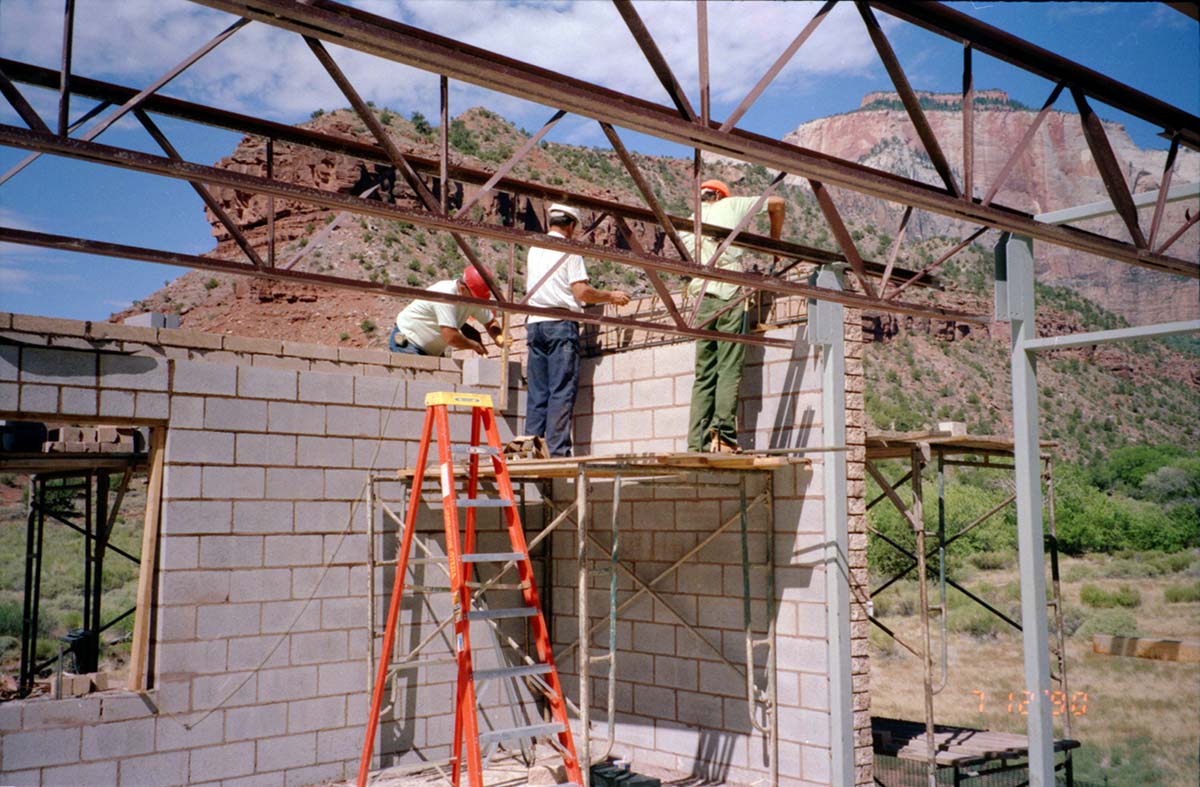 Men laying bricks during the construction of headquarters addition.