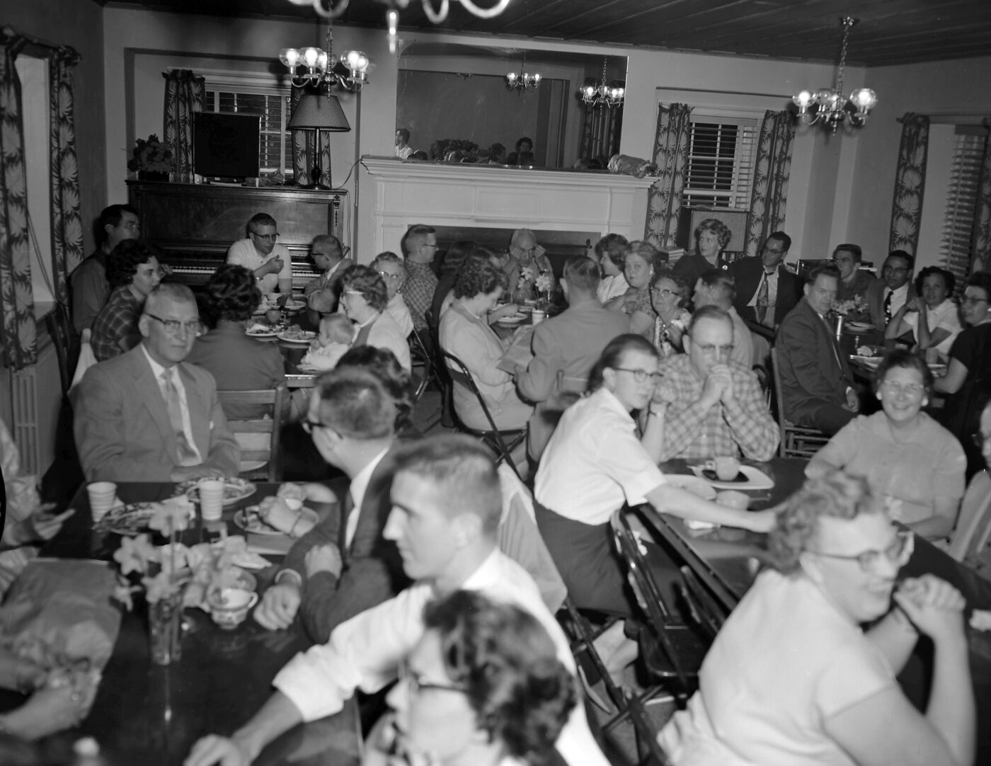 Men and women seated at tables at Harry Brockmeier's retirement party in the ranger dormitory.