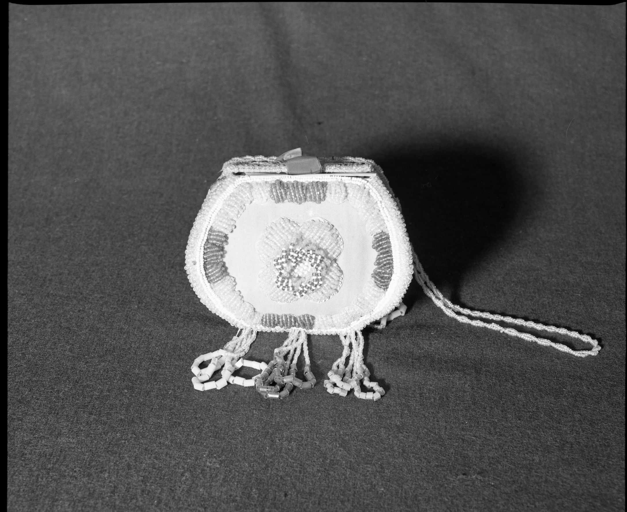 Marie Rozier Collection, Catalog No. 2-113. Object: Beaded box. Dimensions: 6 1/4". Materials: Cardboard, paper, ribbon, cloth, brass sequins and many different kinds of beads. Collection History: "BOX" and "1908" beaded on box. Old handwritten tag on interior states made by the Nattive Americans of the Klamath reservation, Southern Oregon, but this was most likely in the Niagara Falls area. From Kipling. Photographed by Michael Dixon, December 1982. Catalogued by Craig Bates and Barbara Beroza. Yosemite Collections, National Park Service.