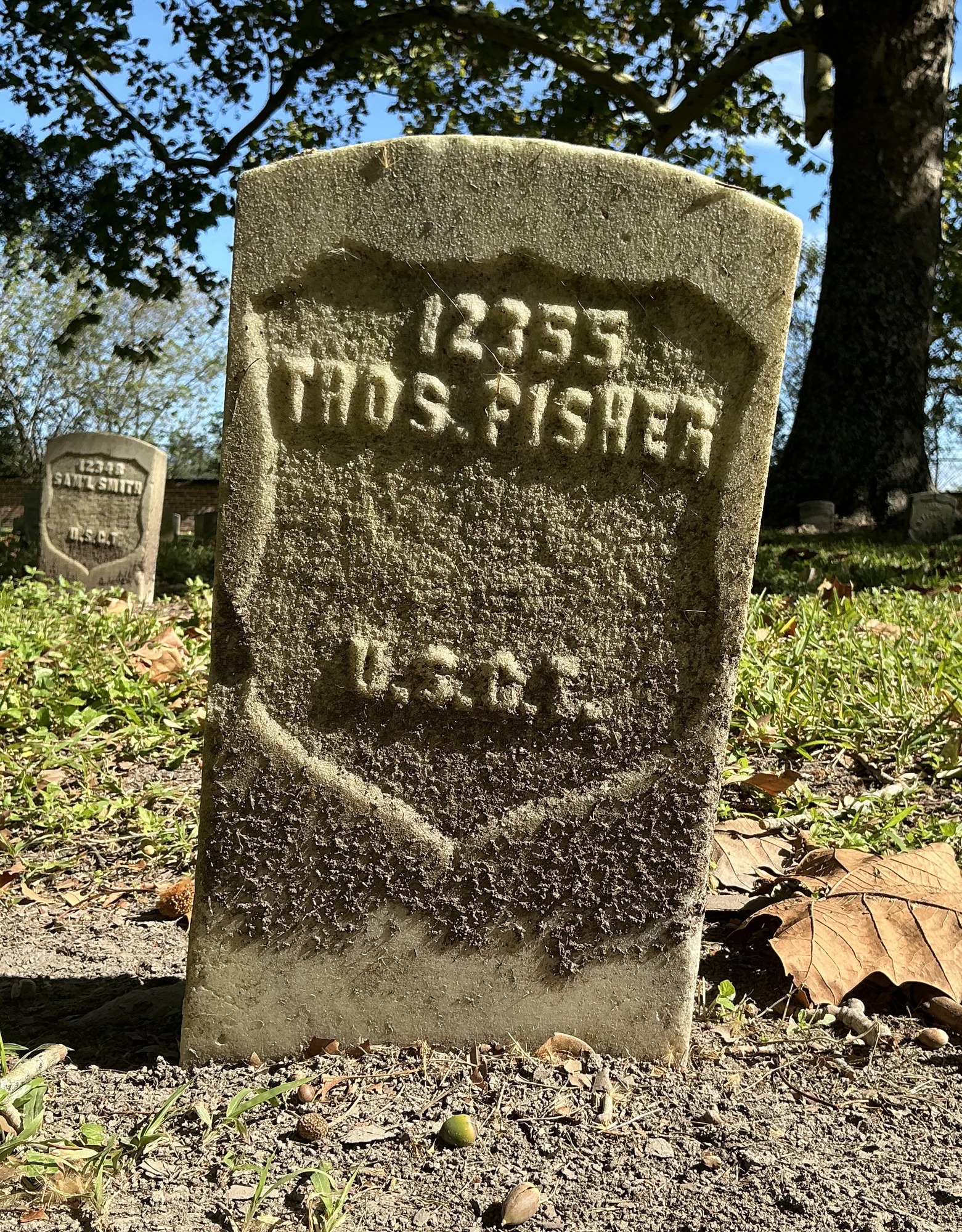 Front of historic upright marble headstone with recessed shield face.