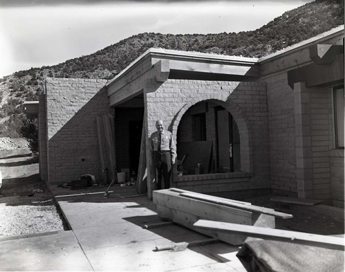 Uniformed man standing near entry way to Kolob Canyons Visitor Center during its construction.