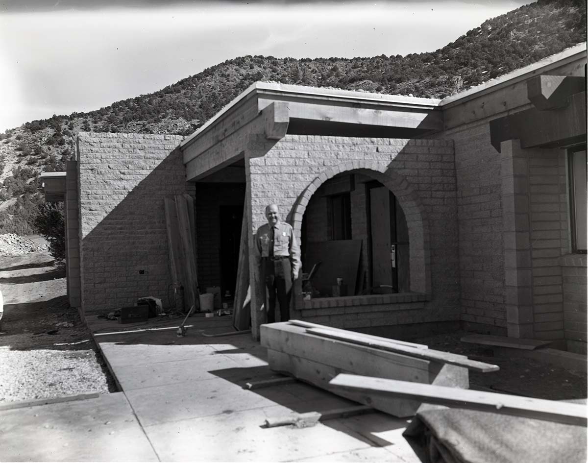 Uniformed man standing near entry way to Kolob Canyons Visitor Center during its construction.