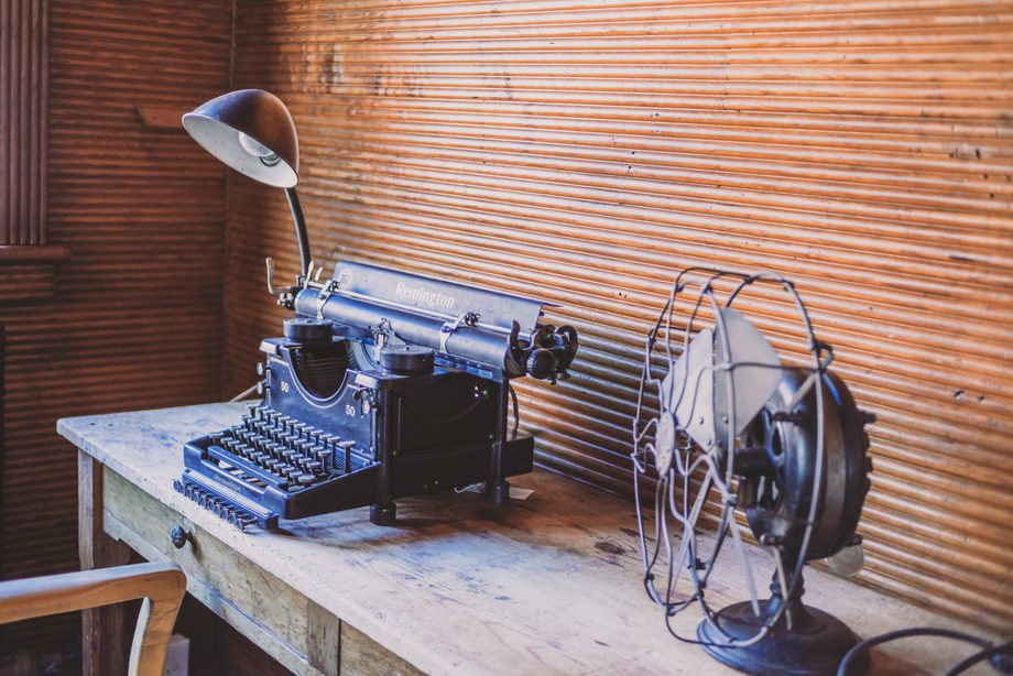 Typewriter, Lamp, and Fan on wooden desk