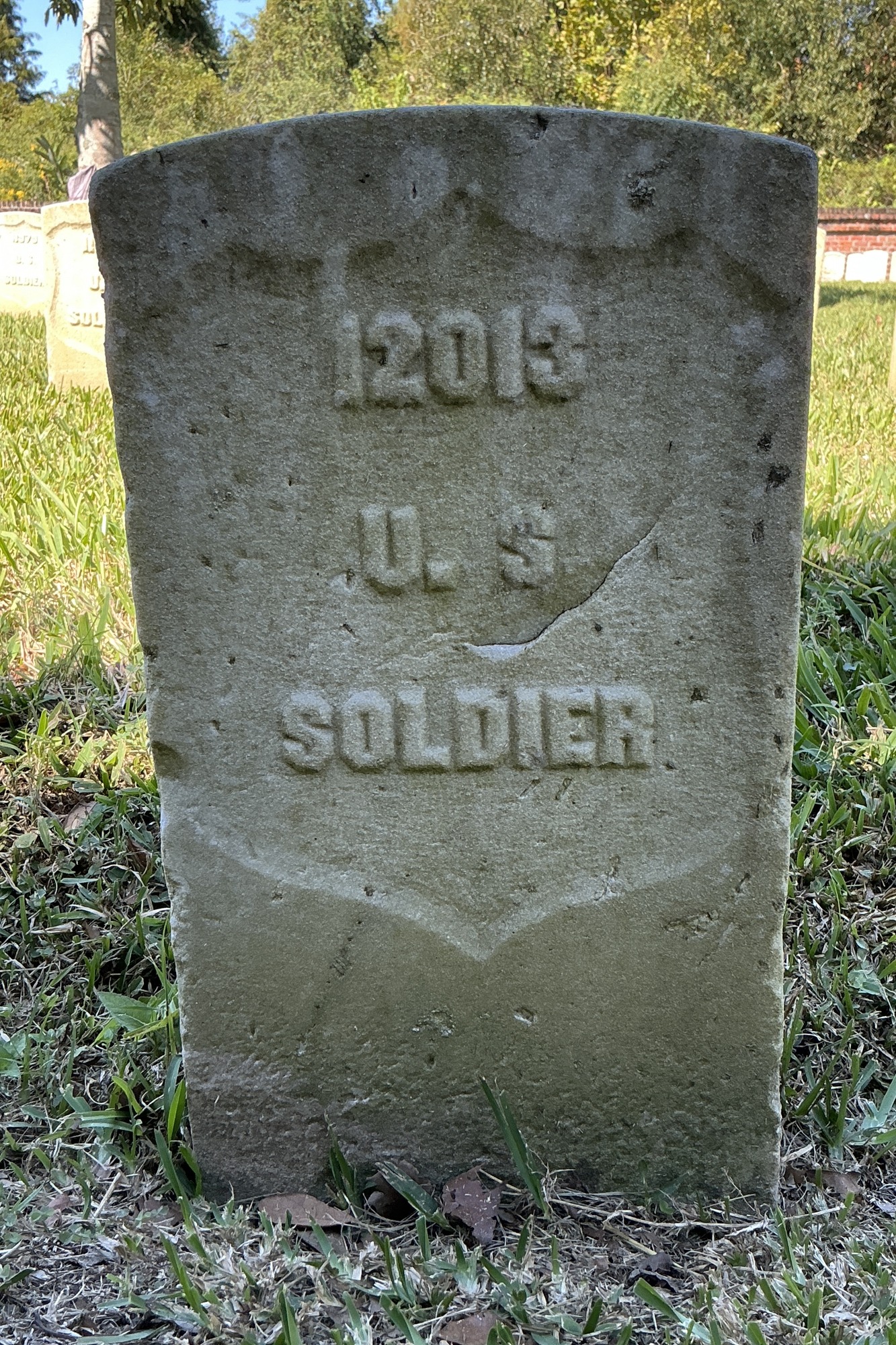Front of historic upright marble headstone with recessed shield face.