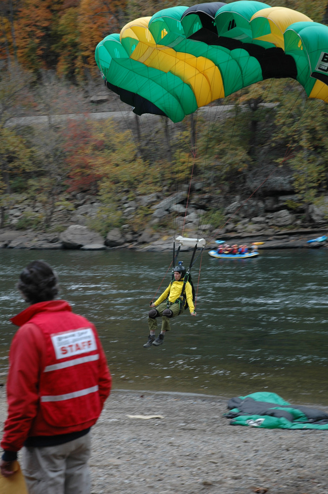 a BASE jumper lands on the shore of the river