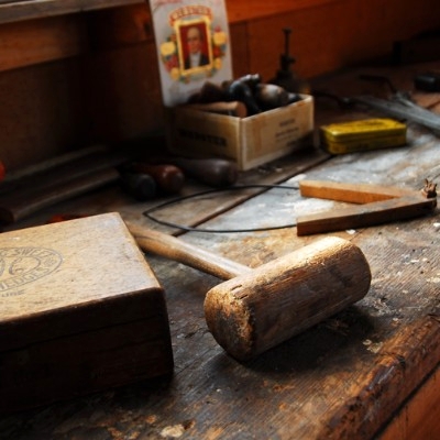 A wooden bench with a mallet and several over small working tools on it.