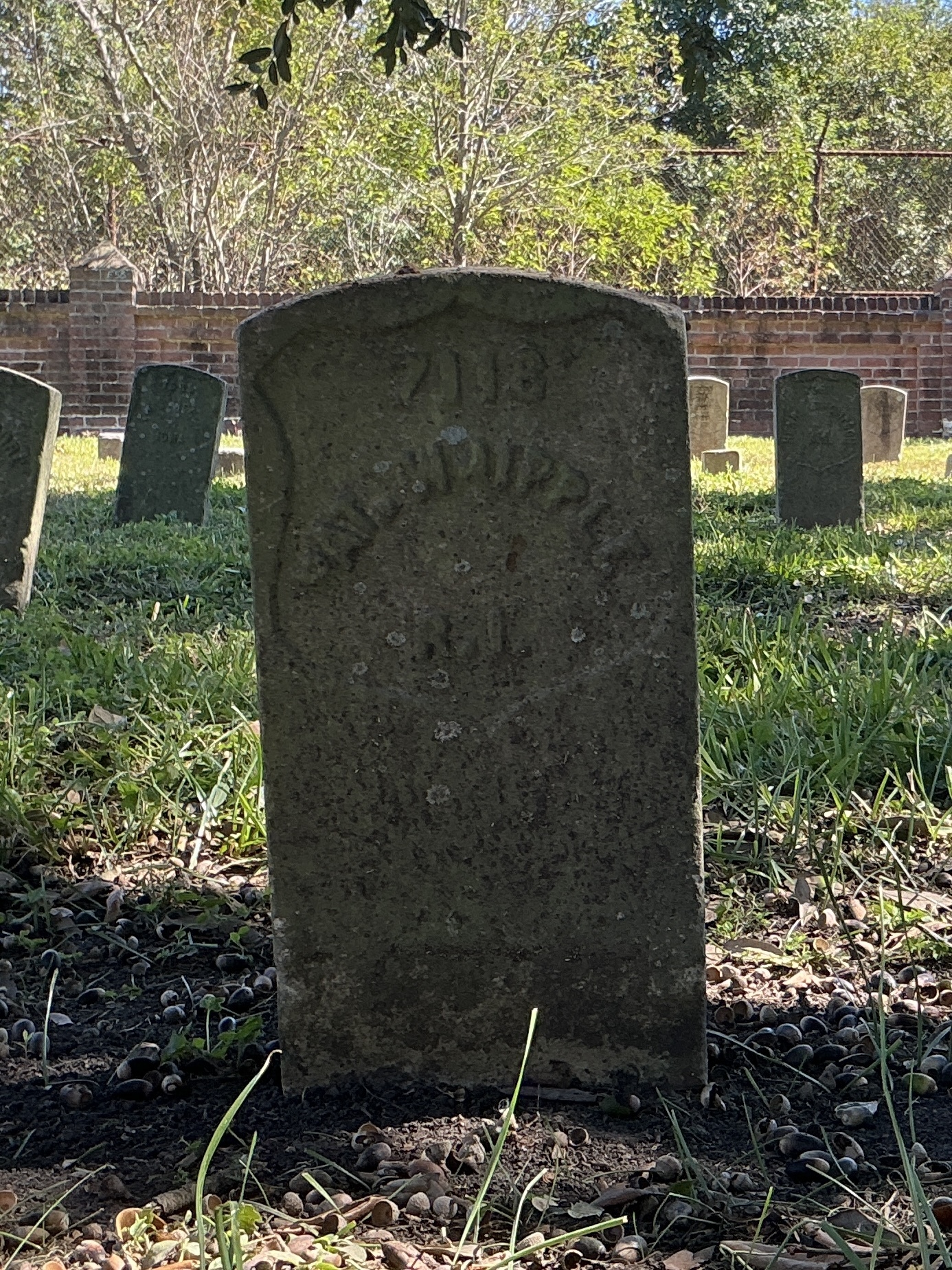 Front of historic upright marble headstone with recessed shield face.