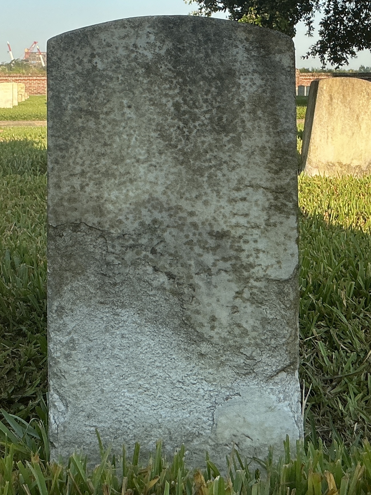 Back of historic upright marble headstone with recessed shield with recessed lettering face.