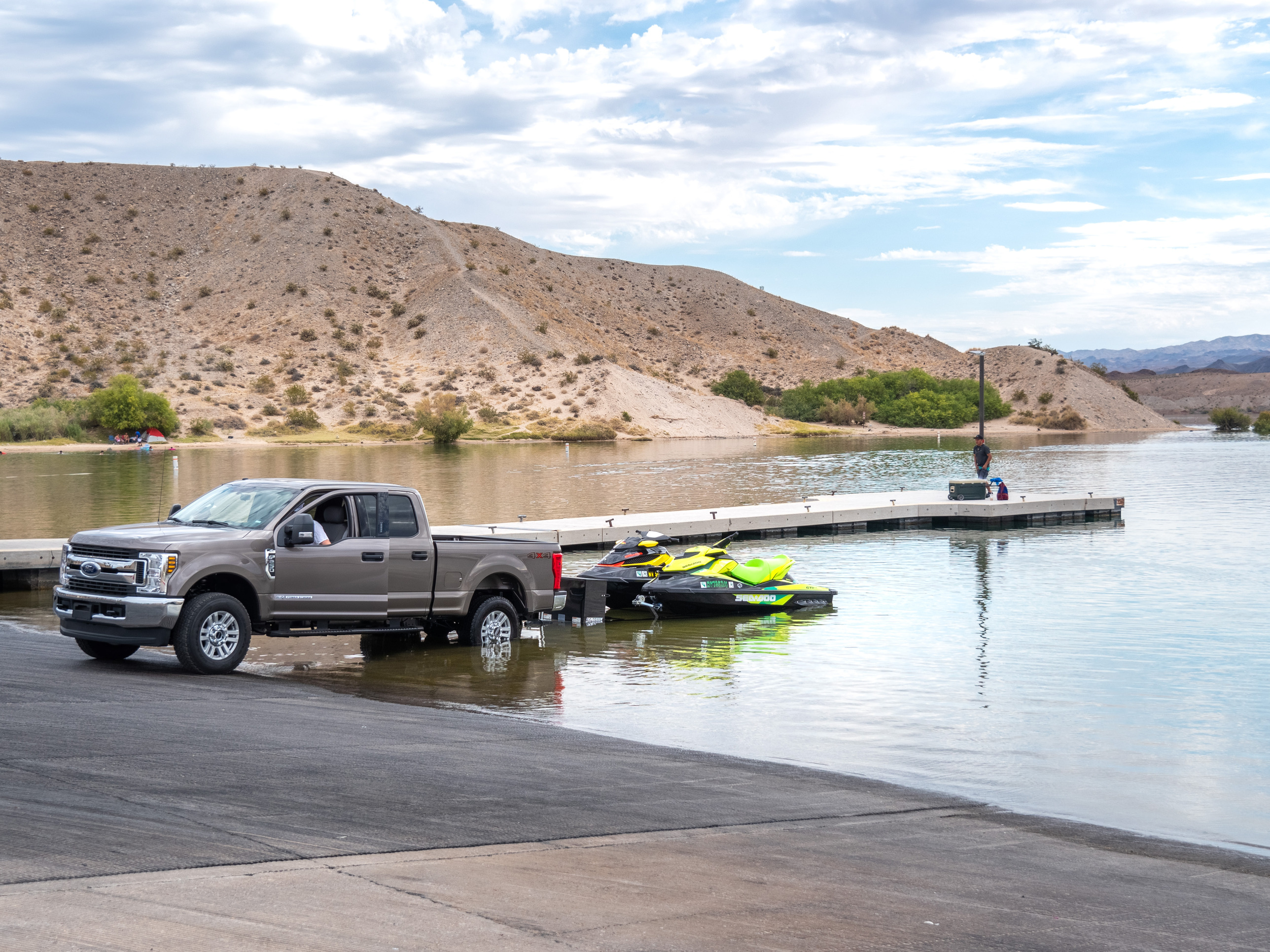 Truck with personal watercraft on trailer entering water