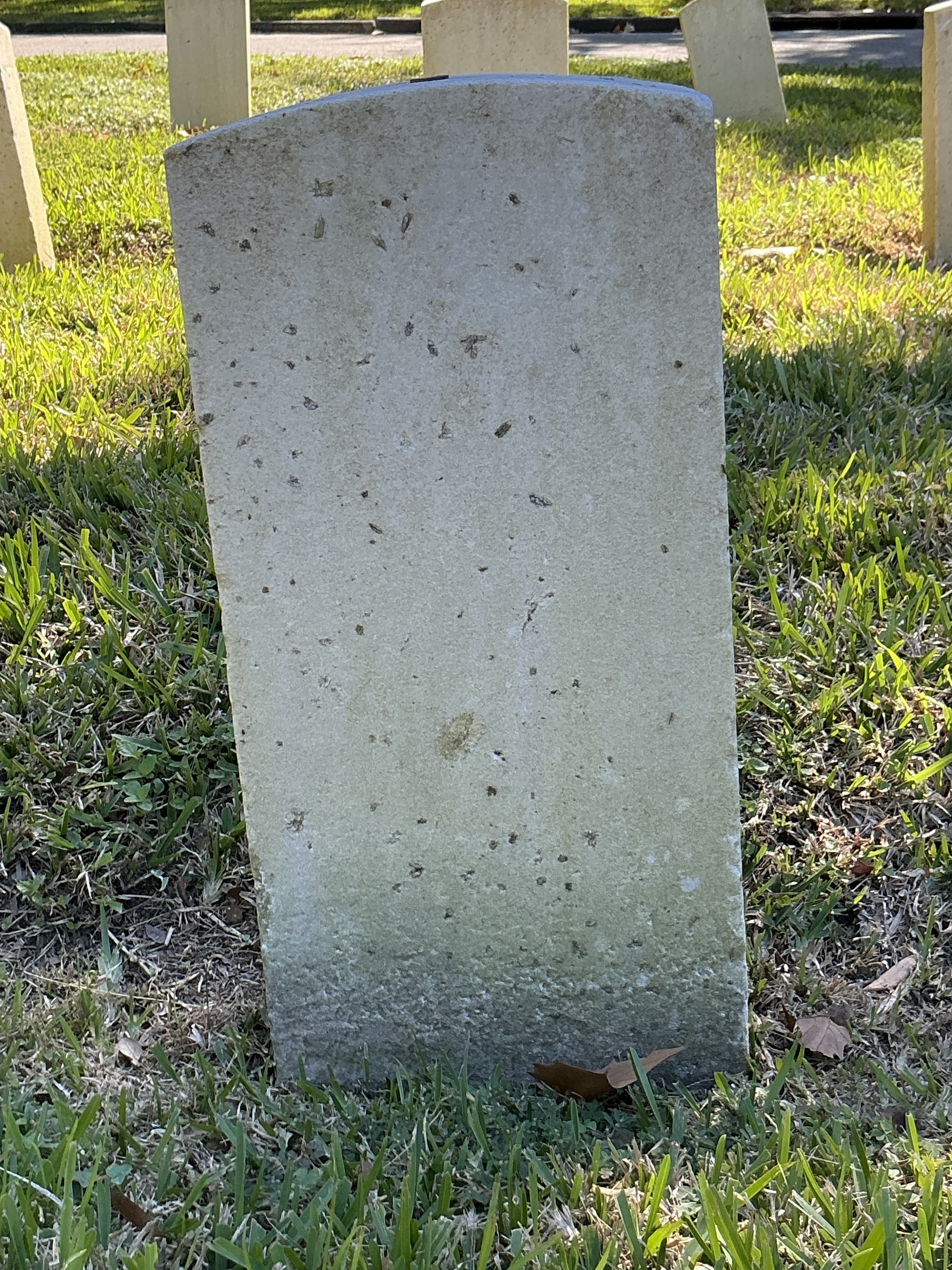 Back of historic upright marble headstone with recessed shield face.