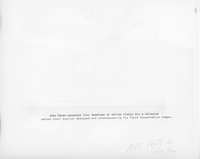 The back of an image with a man drawing plant specimens in an office at Puʻuhonua o Hōnaunau National Historical Park. A caption is tapped to the lower half of the image. The caption reads, “John Garse prepares line drawings of native plants for a Kalapana nature trail booklet designed and constructed by the Youth Conservation Corps.” Along the bottom of the image “N.P.S. Photo by Glen Kaye,” is written in pencil.