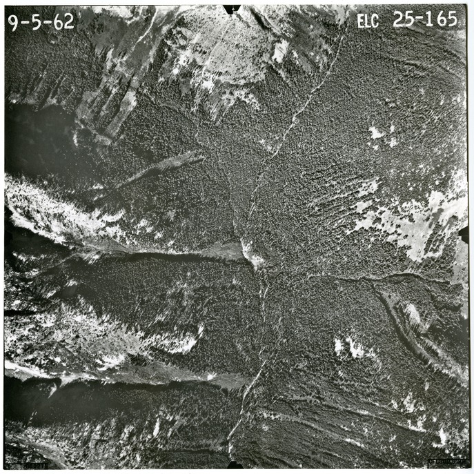 Black and white aerial photograph of glaciated mountain peaks and valleys.