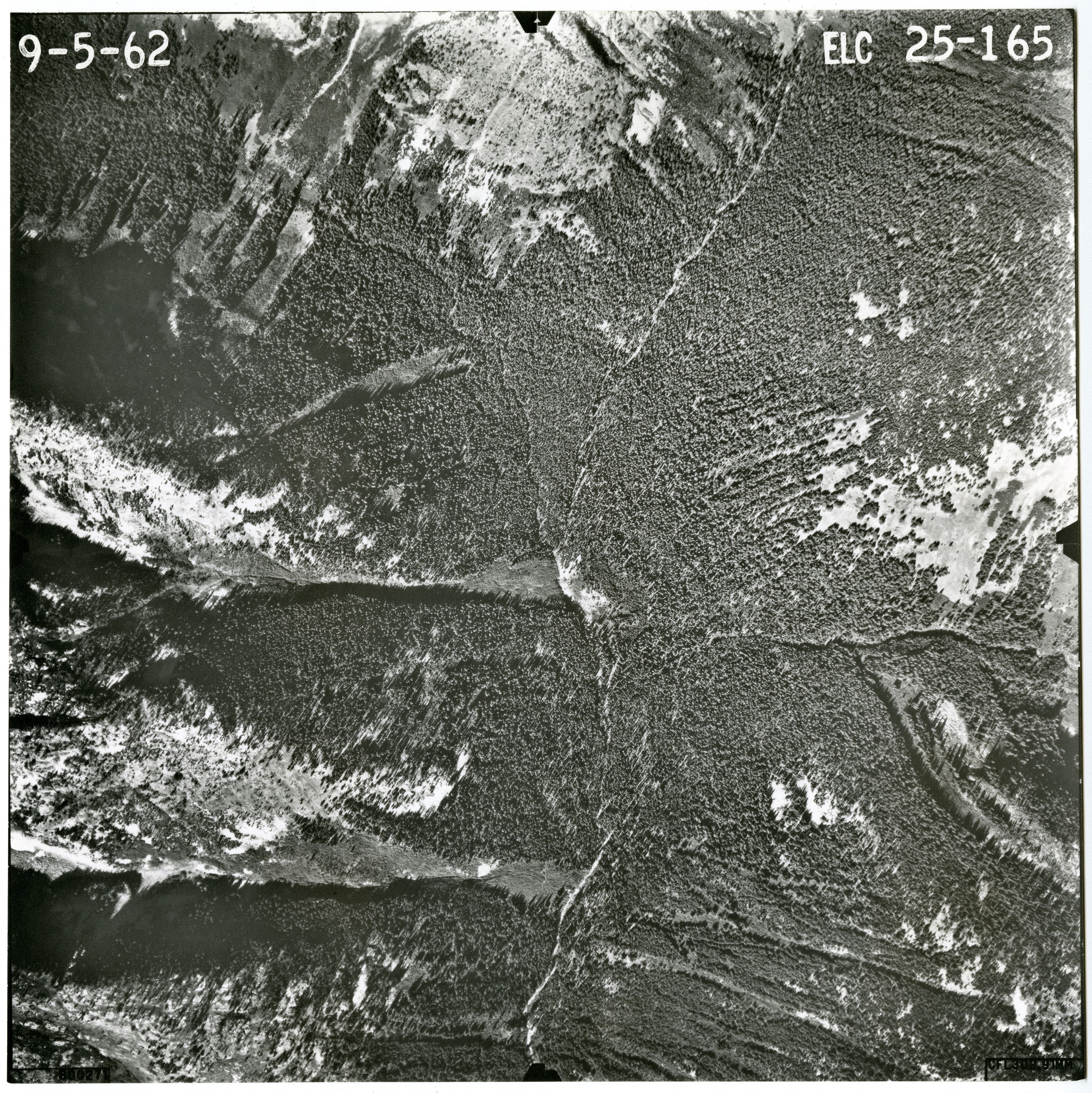 Black and white aerial photograph of glaciated mountain peaks and valleys.