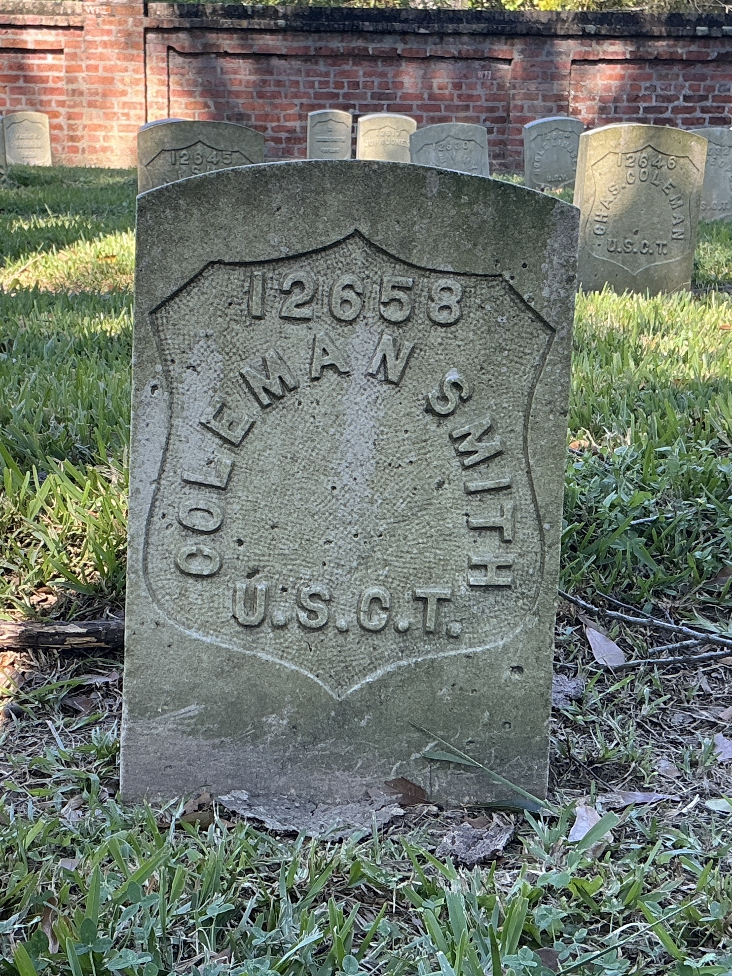Front of historic upright marble headstone with recessed shield face.