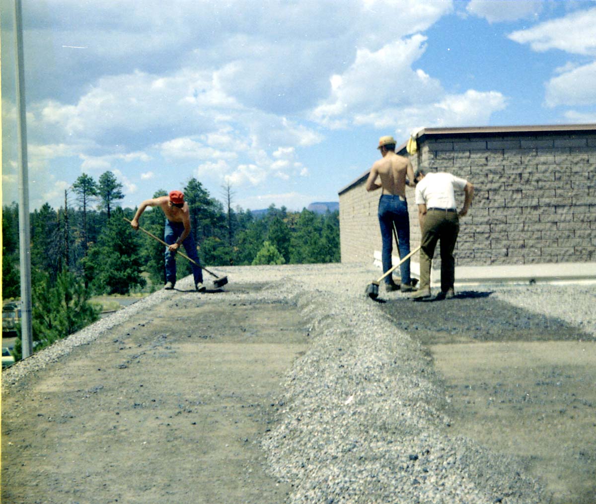 Three men spreading gravel during reroofing project. Bryce Canyon National Park.
