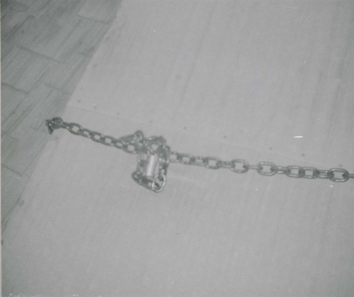 Chain and lock on hatch of water tank roof, prior to reroofing project.