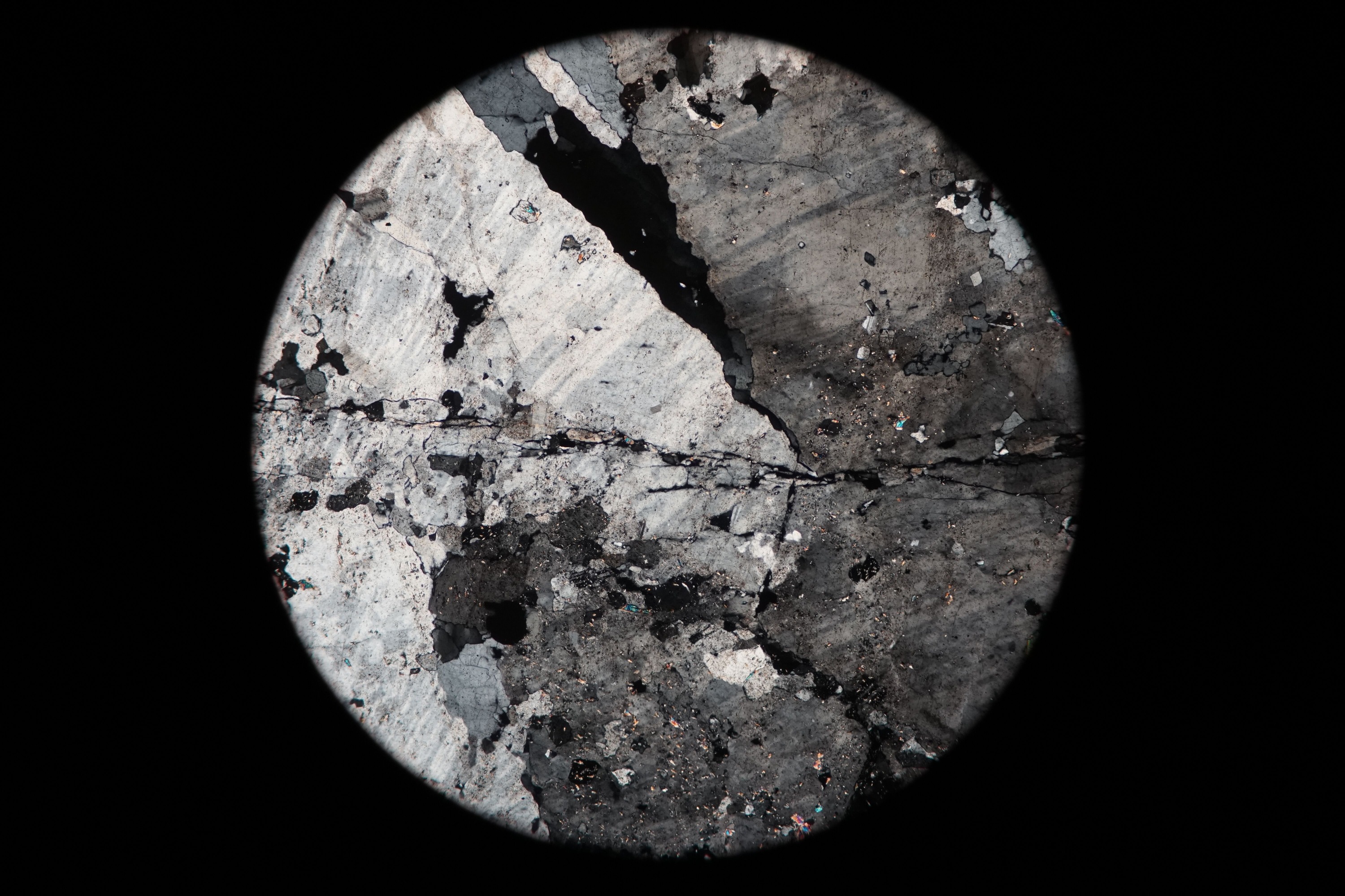Circular microscopic image of rock structure.