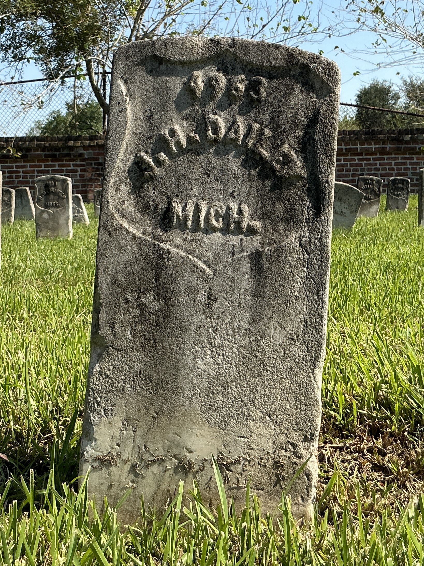 Front of historic upright marble headstone with recessed shield face.