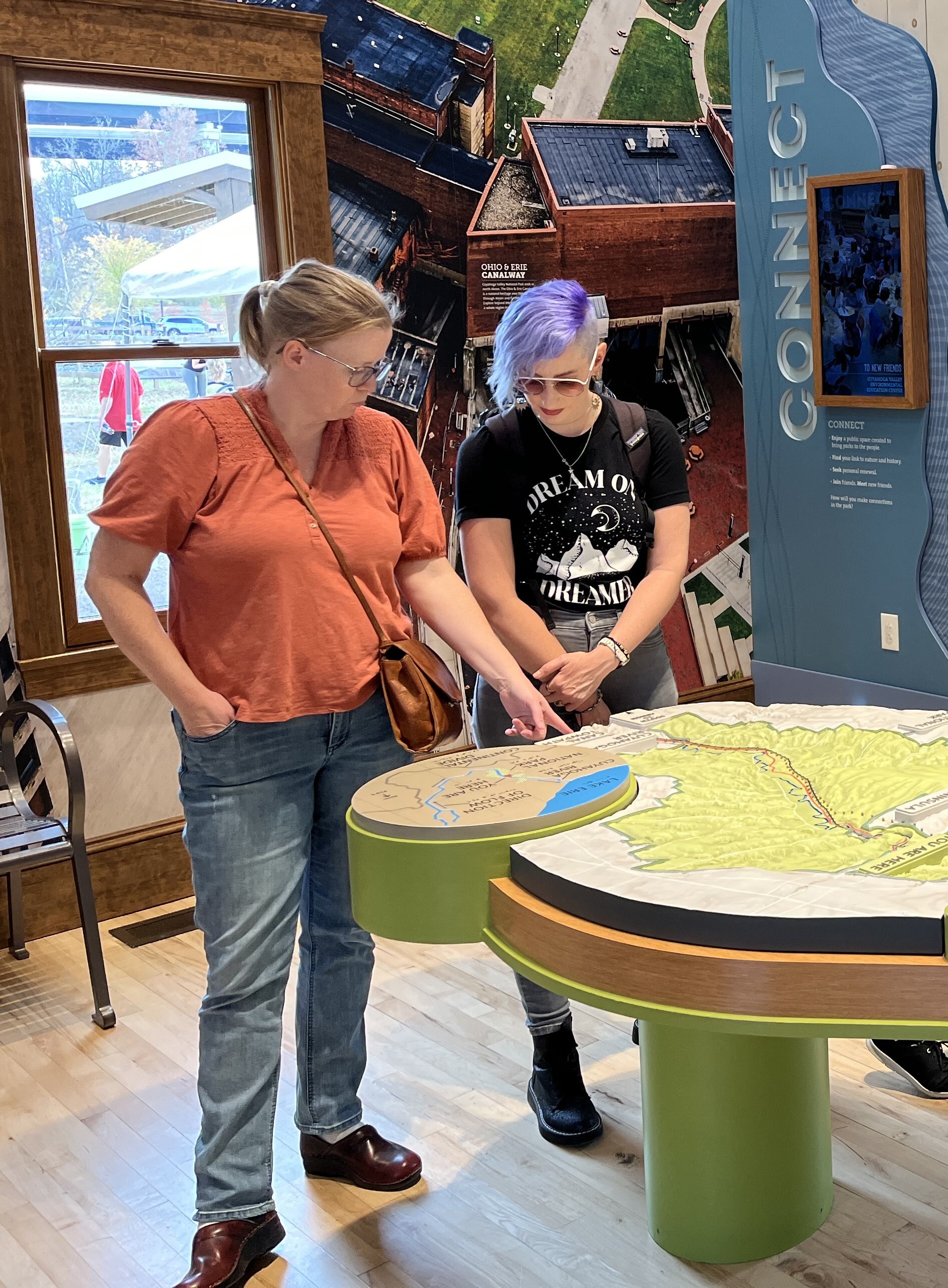 Visitors pointing at a museum exhibit with a table map